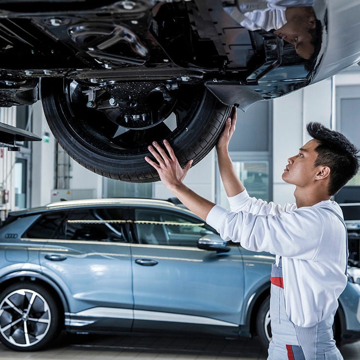 An Audi certified technician inspecting a tire on an Audi. 
