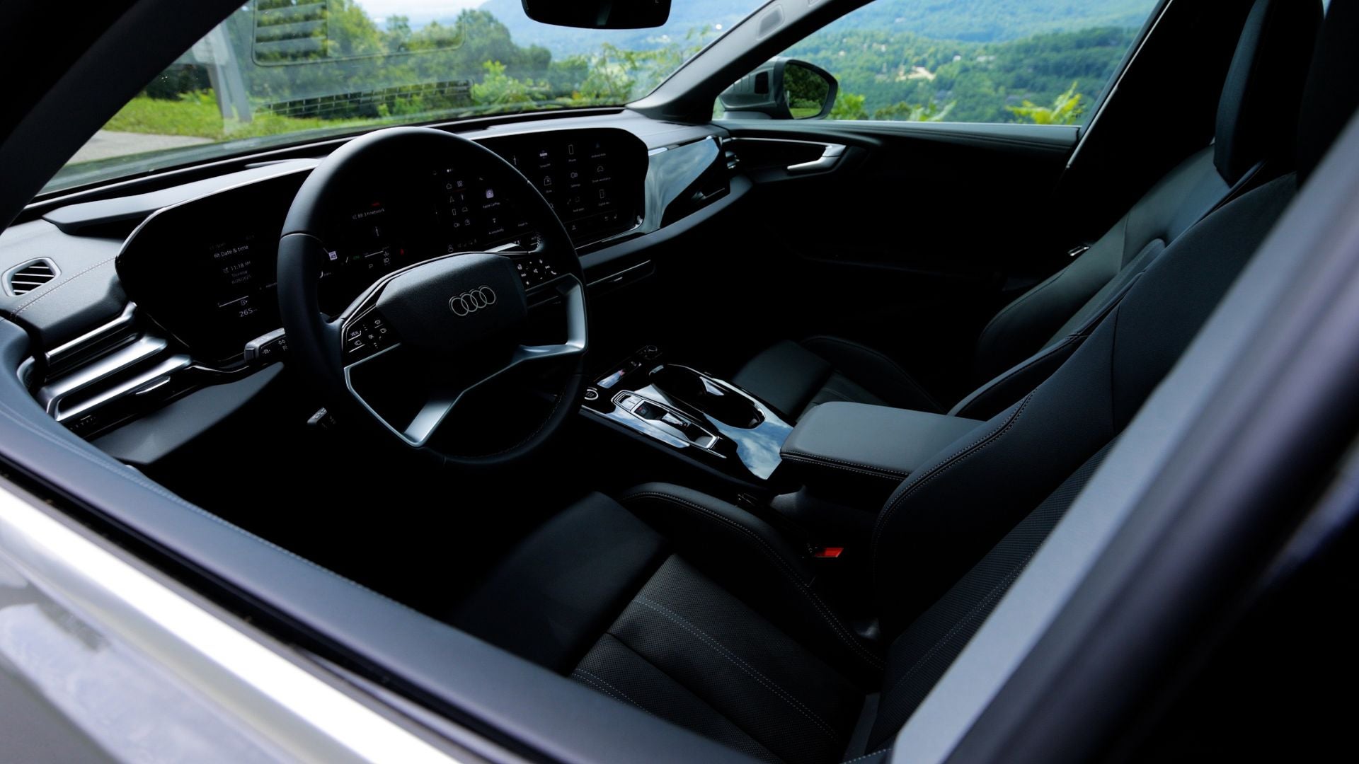 All black interior of the new Audi A5. There are trees visible out the front window