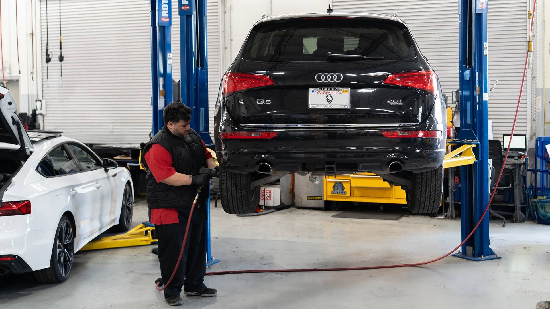 Audi service technician servicing a vehicle.
