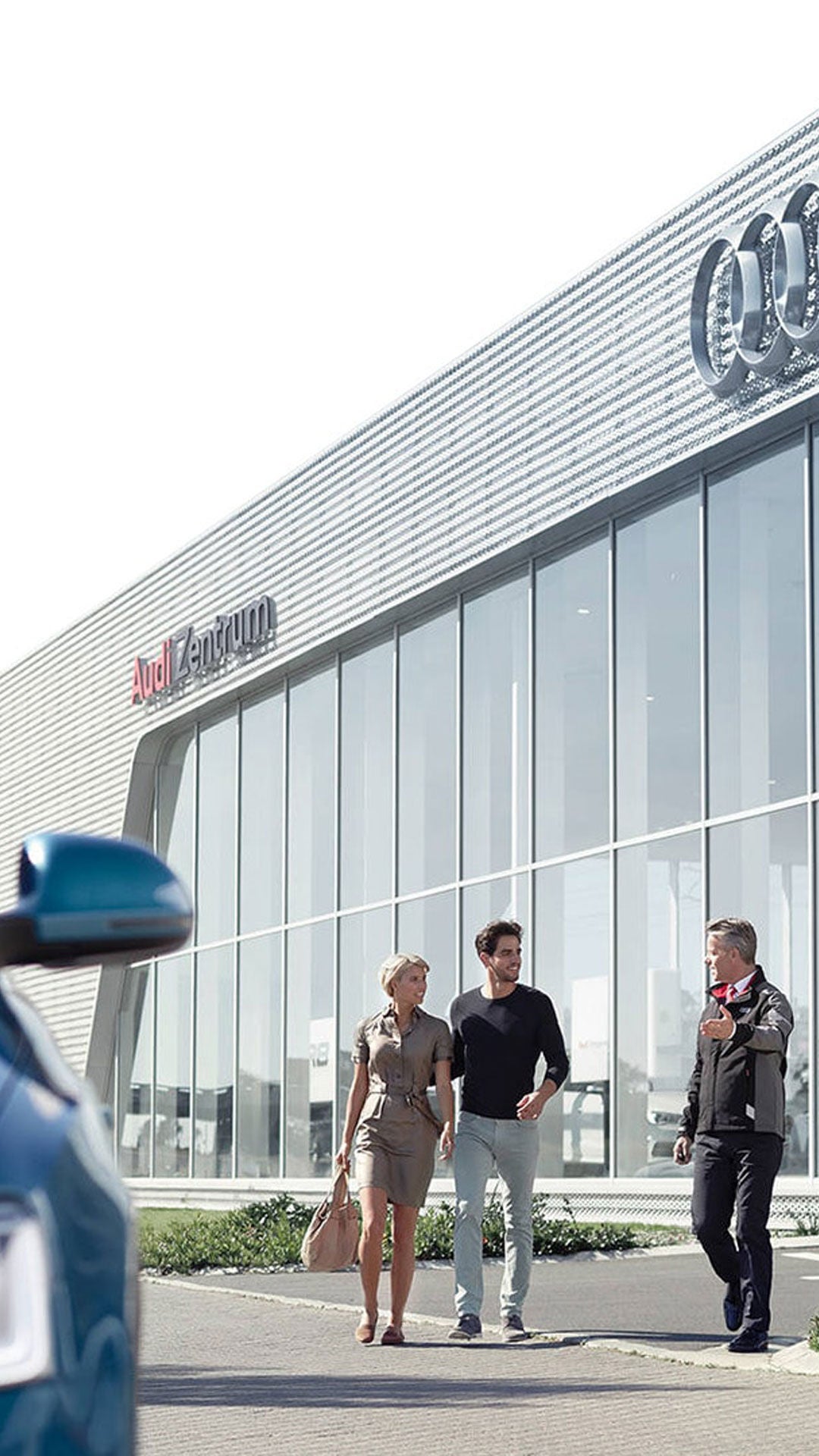 Audi employee leading two owners to their Audi.