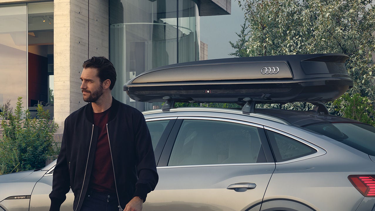 A man walking away from his Audi vehicle.