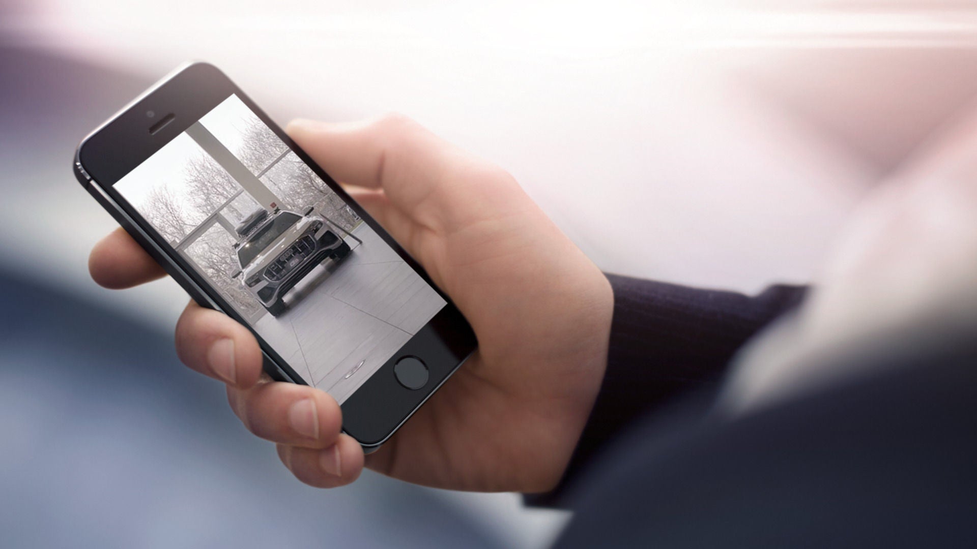 Close-up of a person using their smartphone to view an Audi vehicle on display in the virtual showroom.