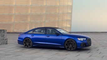 Side view of the Audi S8 parked by a building.