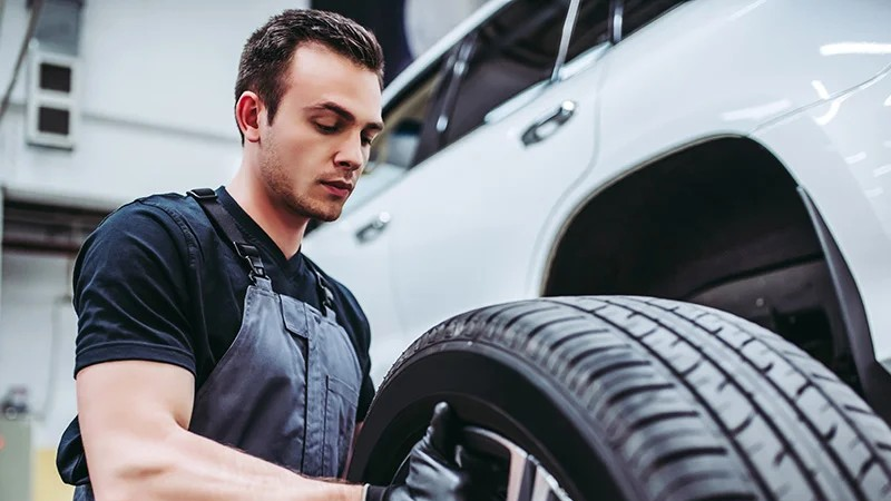 Audi service technician servicing a vehicle.