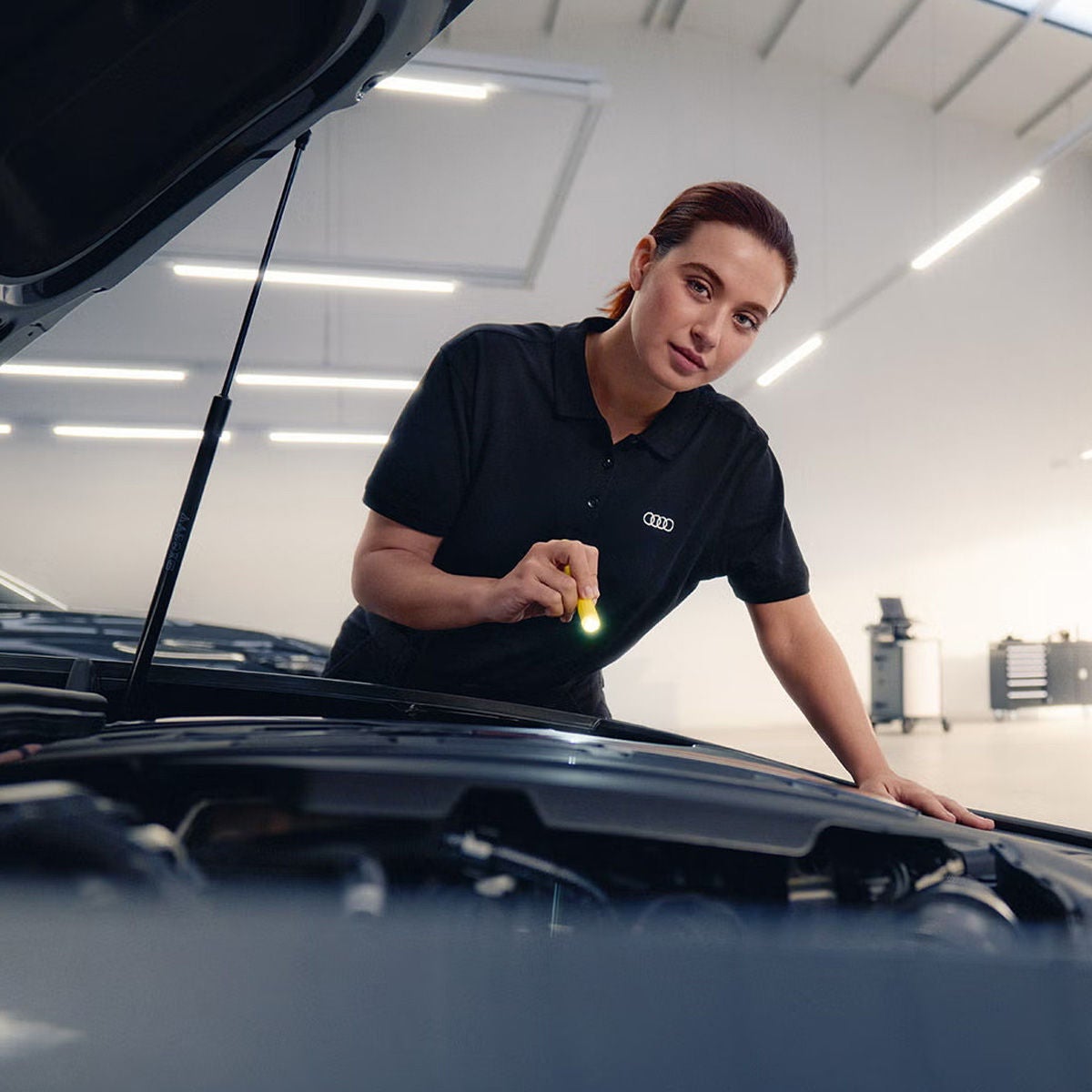 An Audi technician inspecting a vehicle.