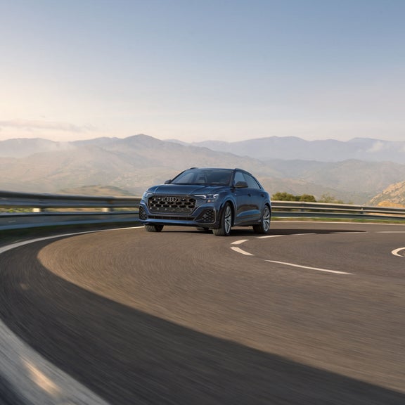 Three quarter front view of the Audi Q8 accelerating. 