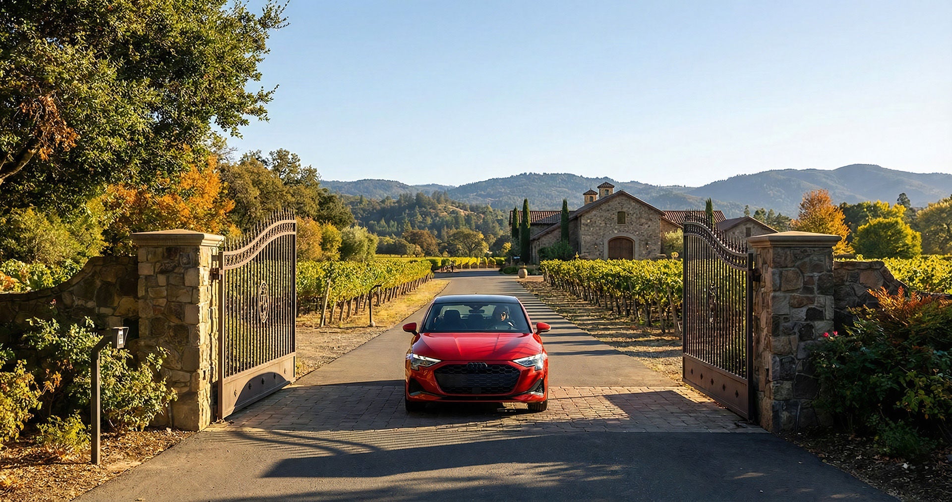 A 2026 Audi A3 in red showing the dimensions as it drives through the gate of a Nappa Valley winery