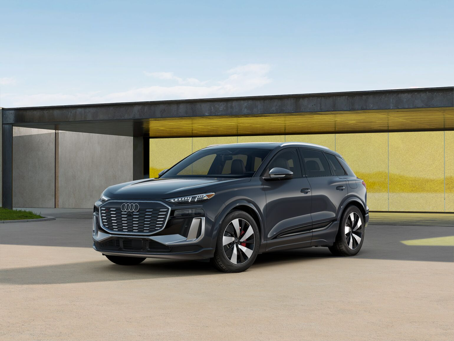Black sq6 e-tron front-facing, towards the left with a yellow wall in the background.