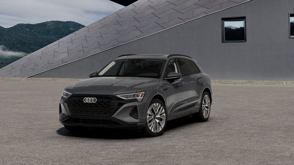 Elevated three-quarter front profile of a gray Audi Q8 e-tron®. 