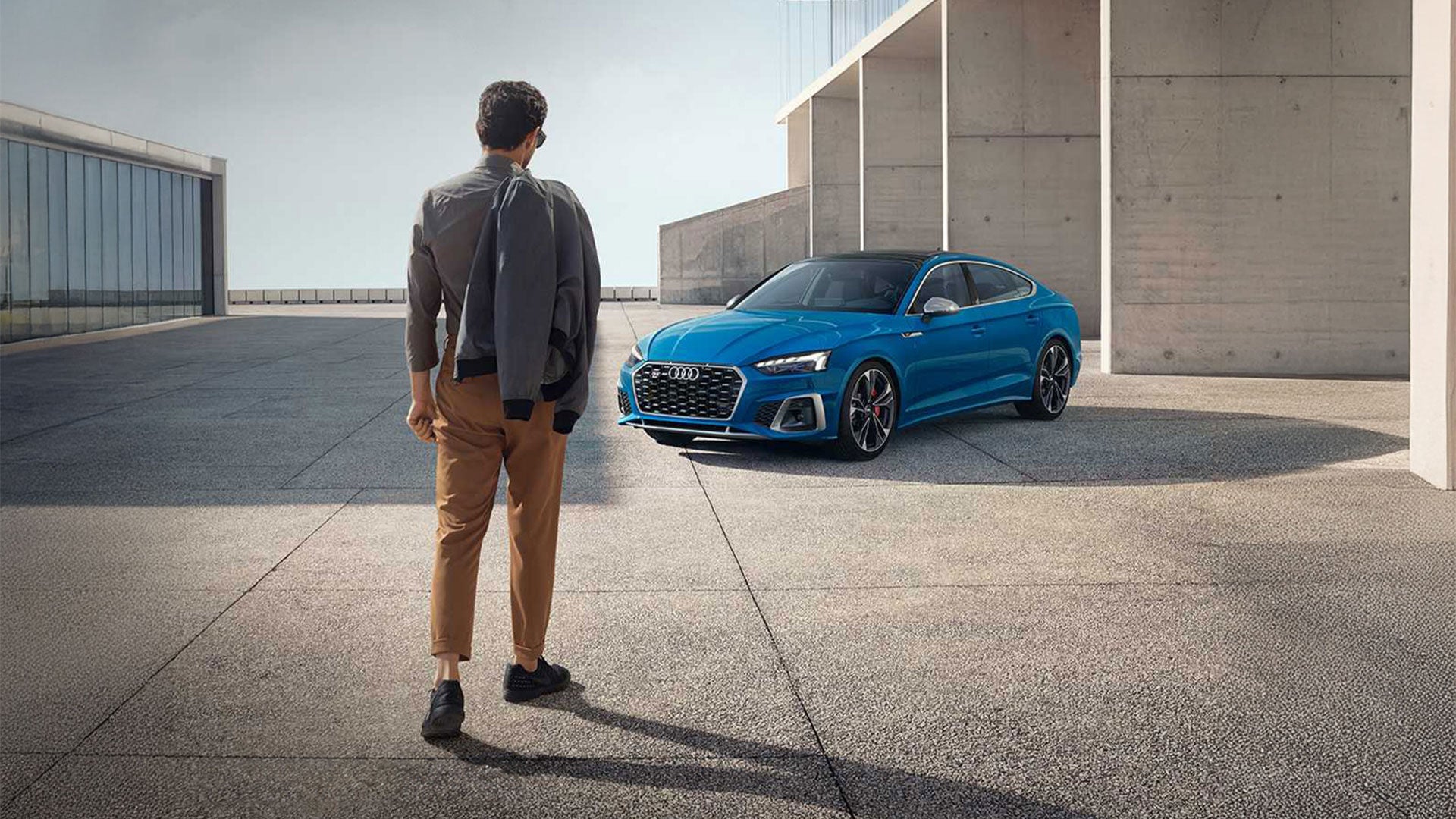 Man standing in front of a blue Audi A3.
