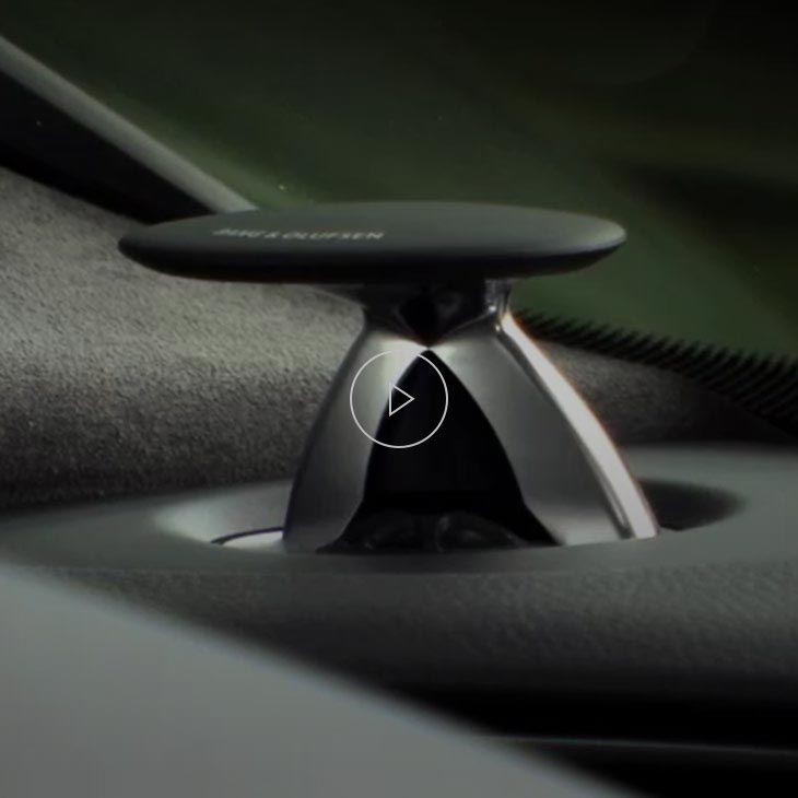 A close-up photo of a Bang & Olufsen speaker inside an Audi vehicle.