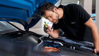 Audi technician inspecting an engine