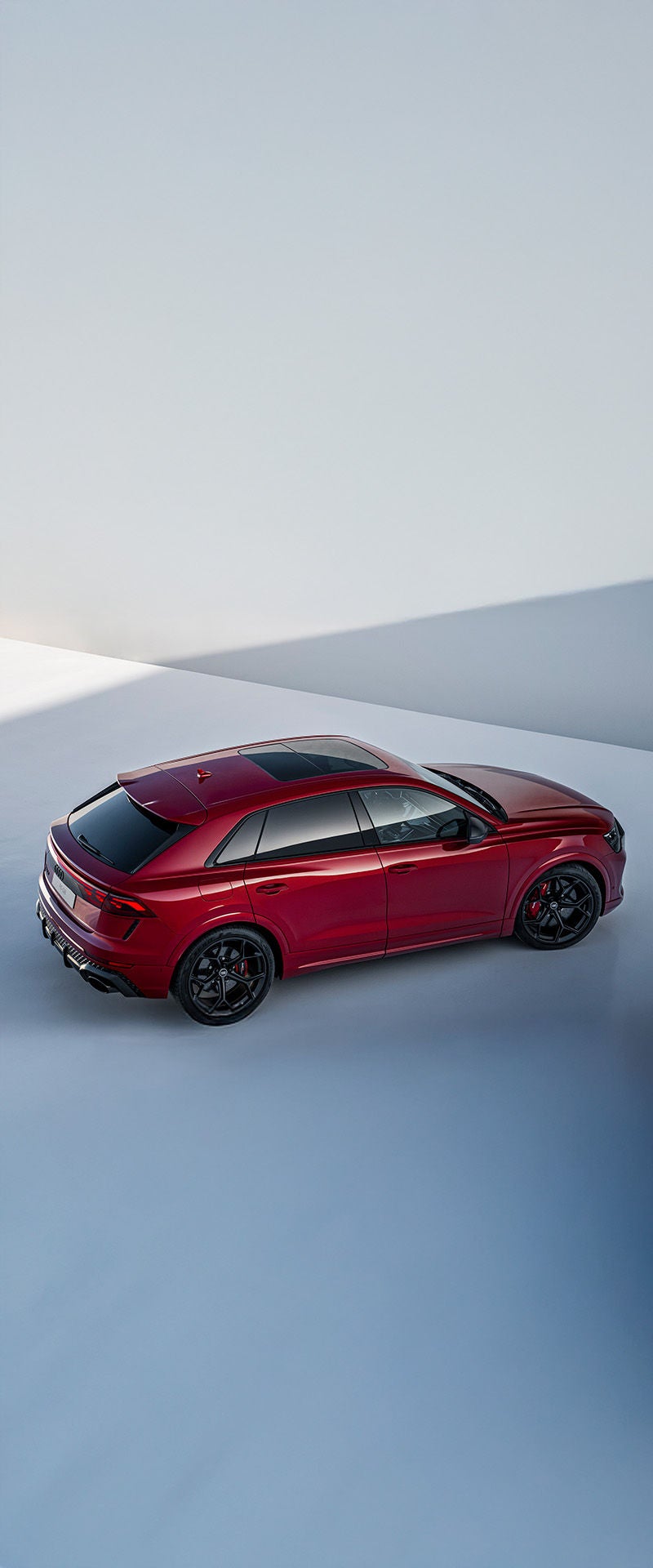 2025 Audi RS Q8 in red exterior photo from top down parked in an abstract grey background