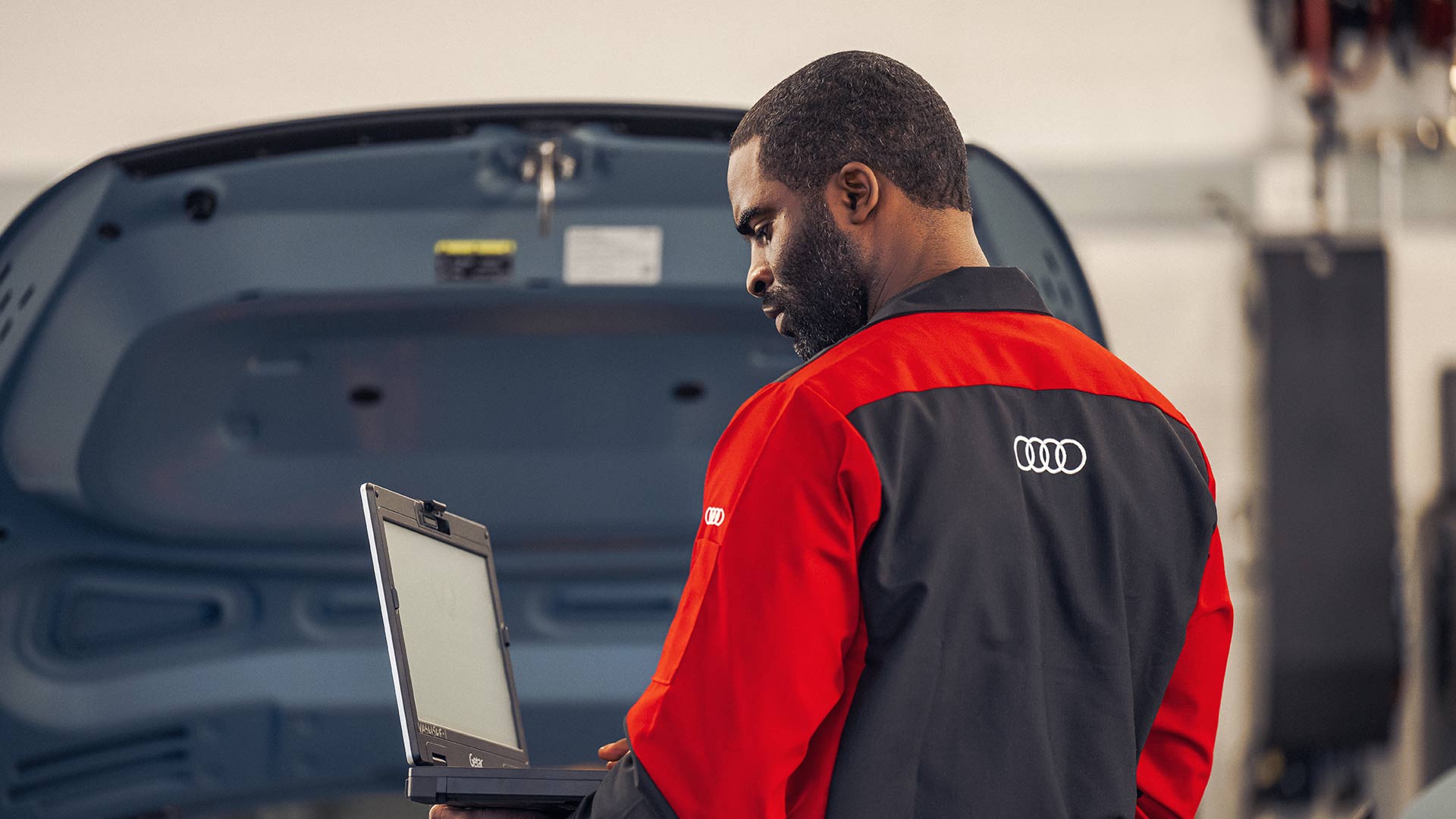 An Audi technician viewing a laptop.