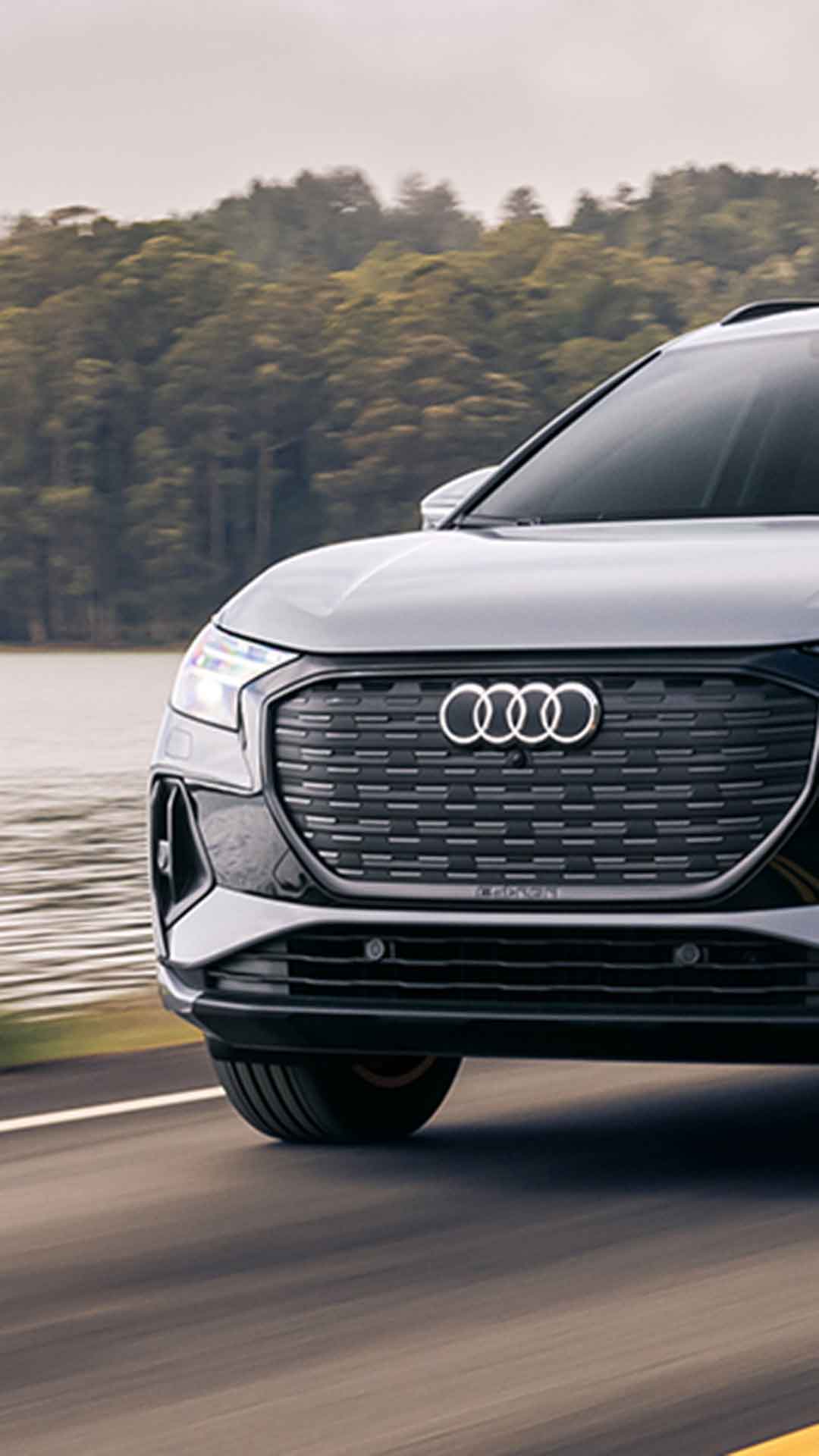 Three-quarter front view of an Audi Q4 e-tron accelerating.