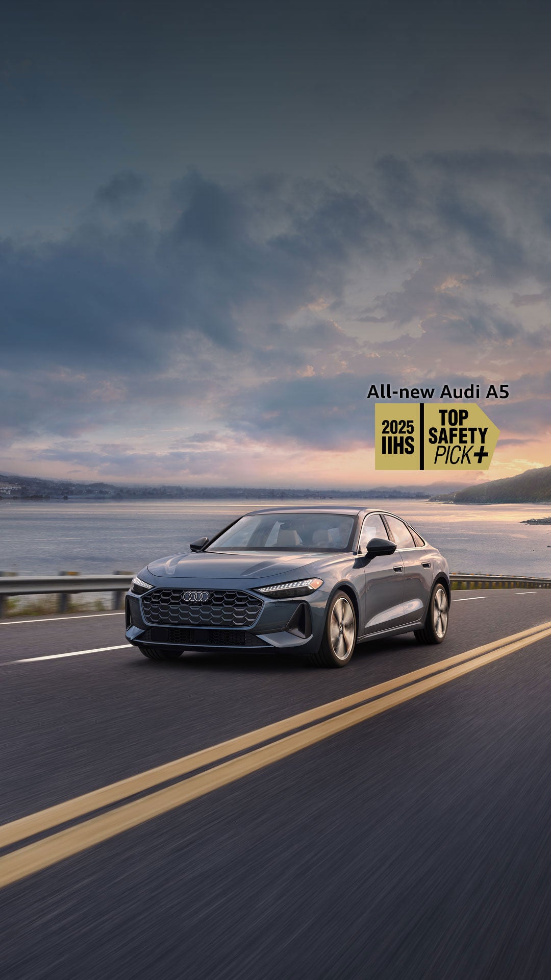 Three-quarter front view of the Audi A5 accelerating on an oceanside road. 2025 IIHS Top Safety Pick" logo is next to the car.
