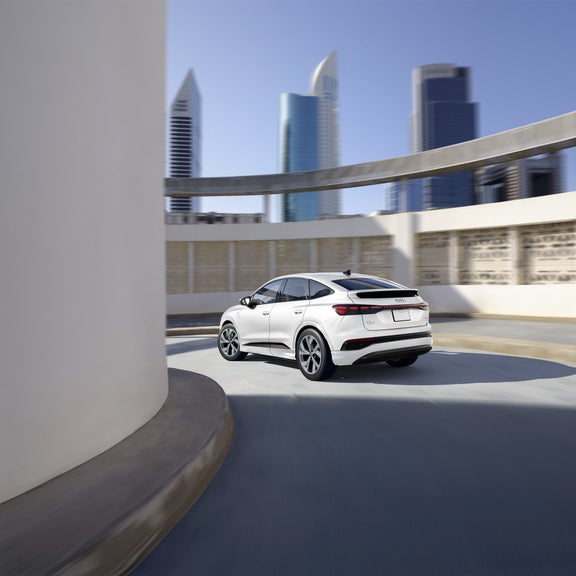 Rear profile of the Audi Q4 Sportback e-tron making a turn. 