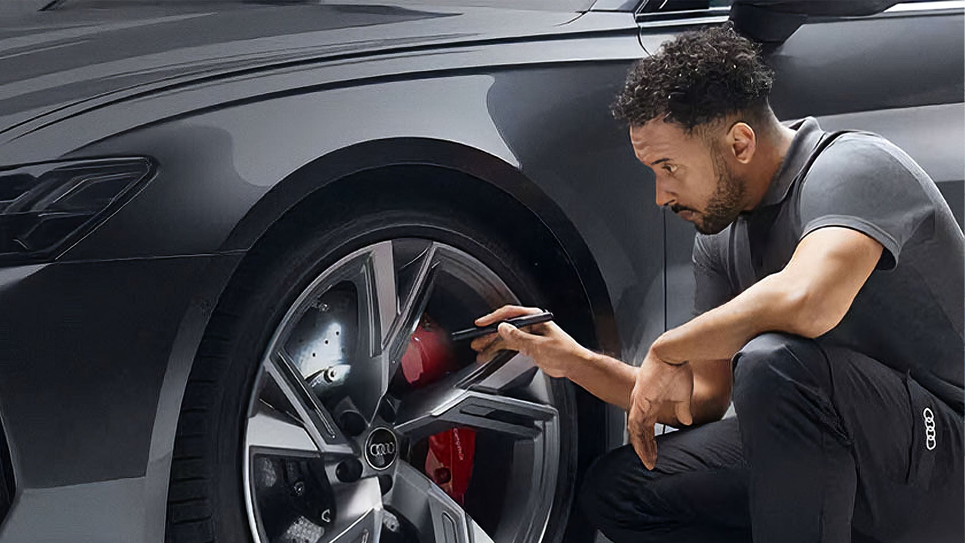 An Audi Technician inspecting a wheel on an Audi