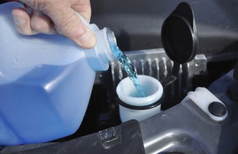 Service technician adding washer fluid