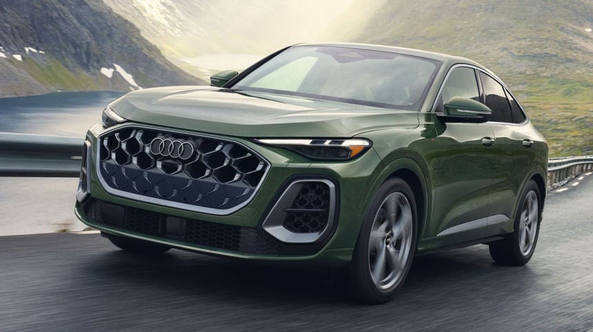 Green Audi Sedan driving on the highway