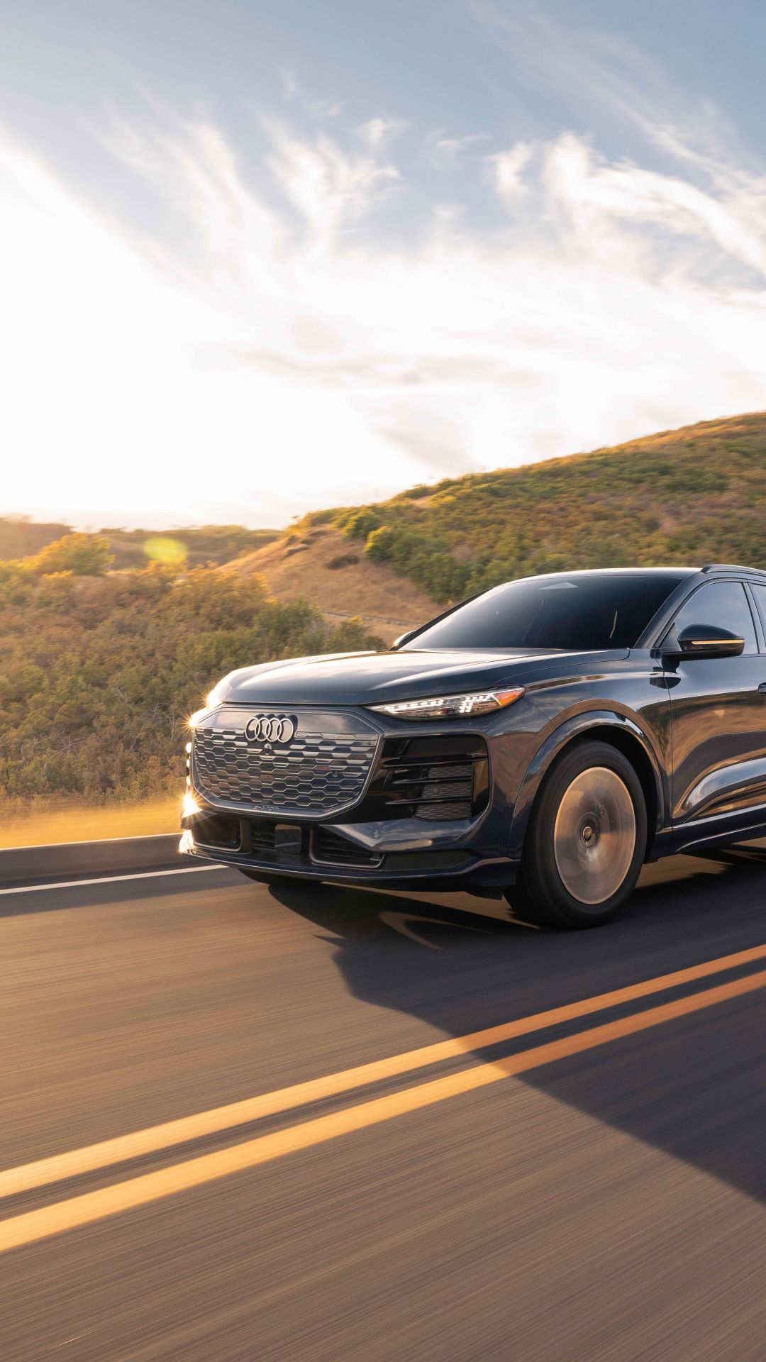 Three quarter profile view of an Audi Q6 e-tron accelerating.