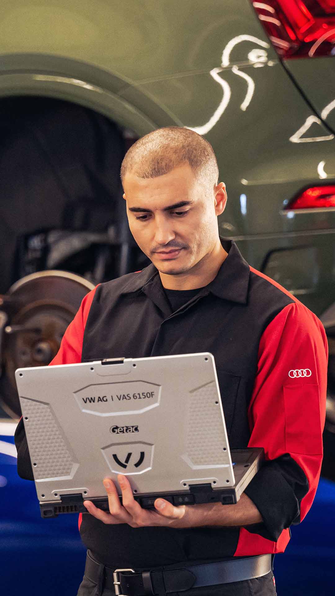 Front profile view of an Audi Service manager running diagnostics on a vehicle.