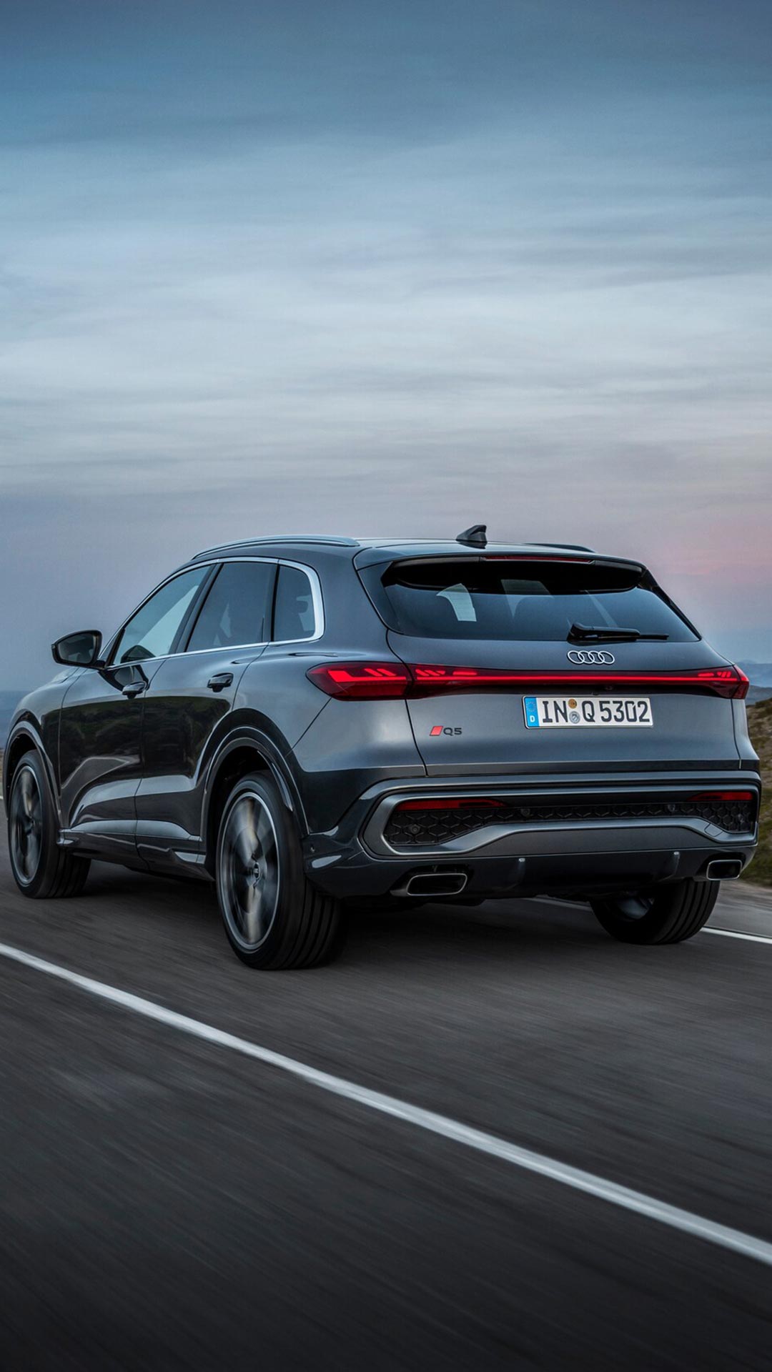 Three-quarter back view of the 2025 Audi Q5 on the road.