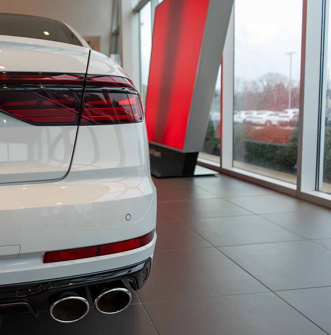 Rear profile view of an audi vehicle parked in the showroom.