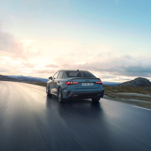 Three-quarter rear view of the Audi RS 3 accelerating.