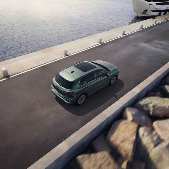 Vue aérienne arrière de l'Audi Q3 accélérant sur un pont.