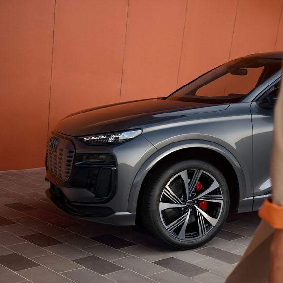 Gros plan de la roue avant d’un Audi SQ6 e-tron gris montrant les étriers de frein avec logo S.