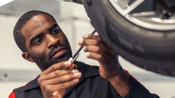 Service technician servicing vehicle.