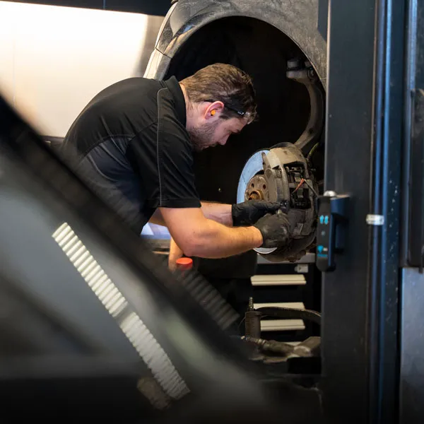 Technicien en mécanique inspectant un véhicule dans l'atelier d'Audi Lévis