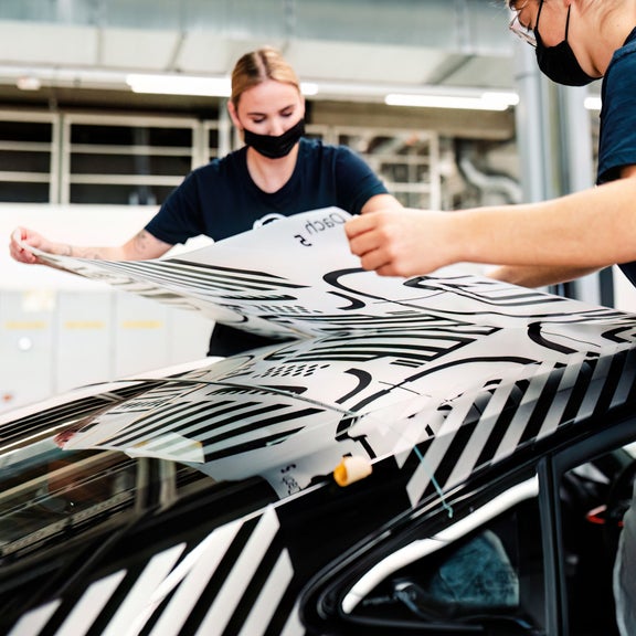 Two Audi employees installing a decal on the Audi RS e-tron GT project_513/2.