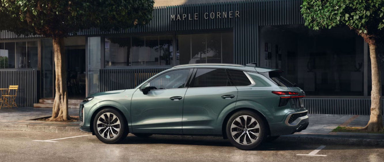 A gray-green 2026 Audi Q3 SUV parked in front of a restaurant