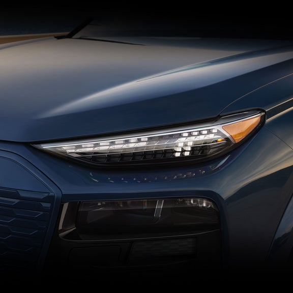 Close up on the front left headlight, showing a DRL signature, on the Audi Q6 e-tron.