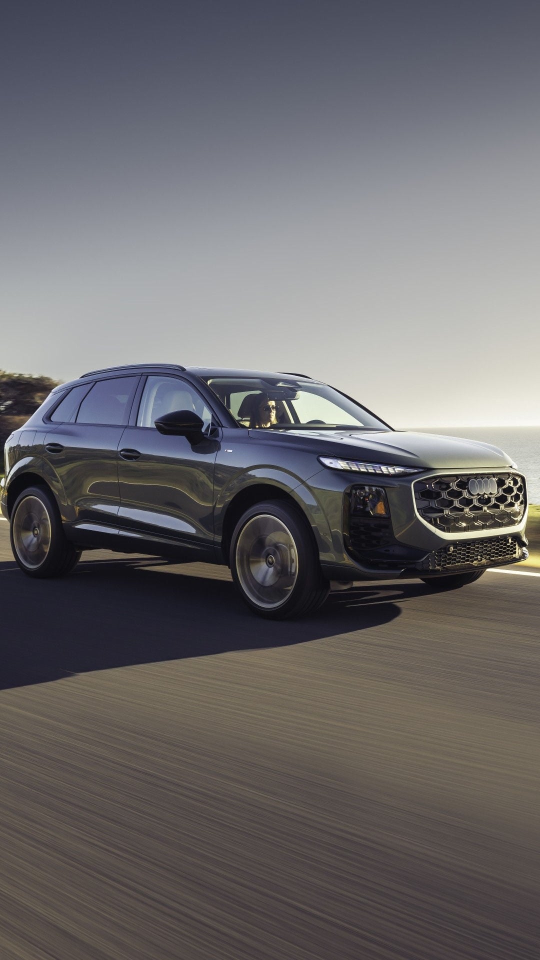 Side view of an Audi Q3 accelerating on highway.
