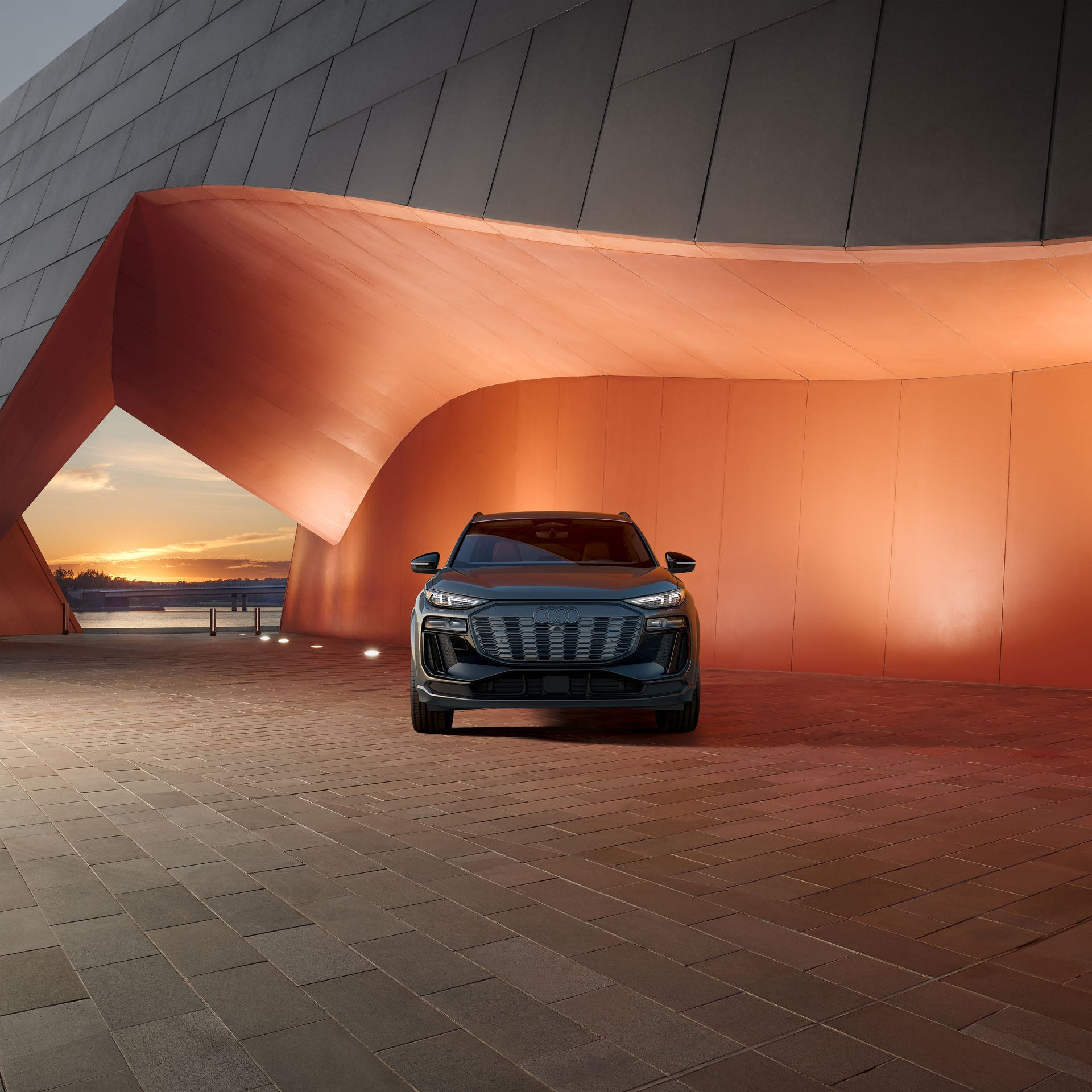 Three-quarter rear view of the Audi RS e-tron GT project 513/2 parked inside of a glass building at night. 