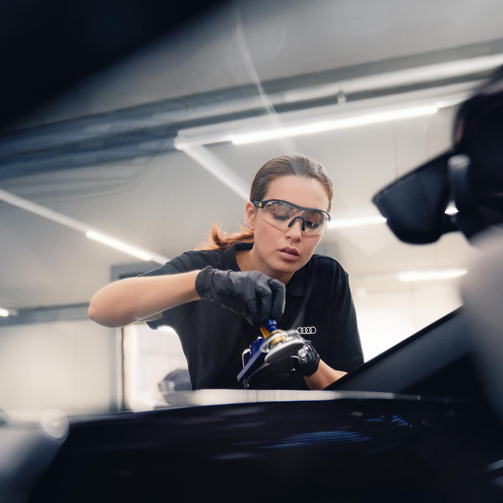 Un technicien Audi inspecte une pièce d’un véhicule Audi.