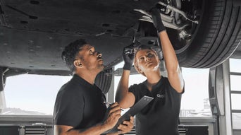 Service technician servicing vehicle. 