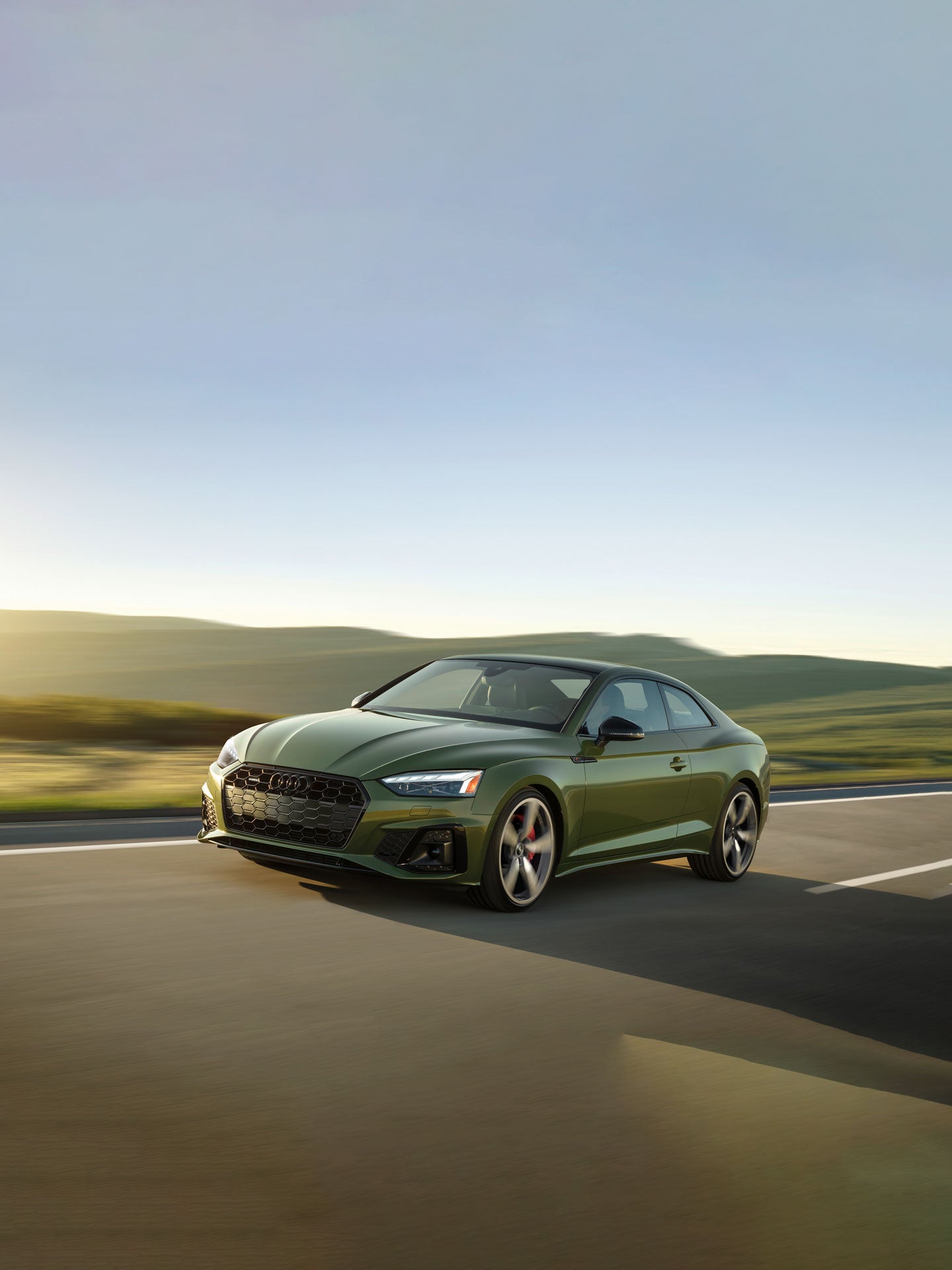 Three-quarter front view of the Audi A5 Coupe accelerating.