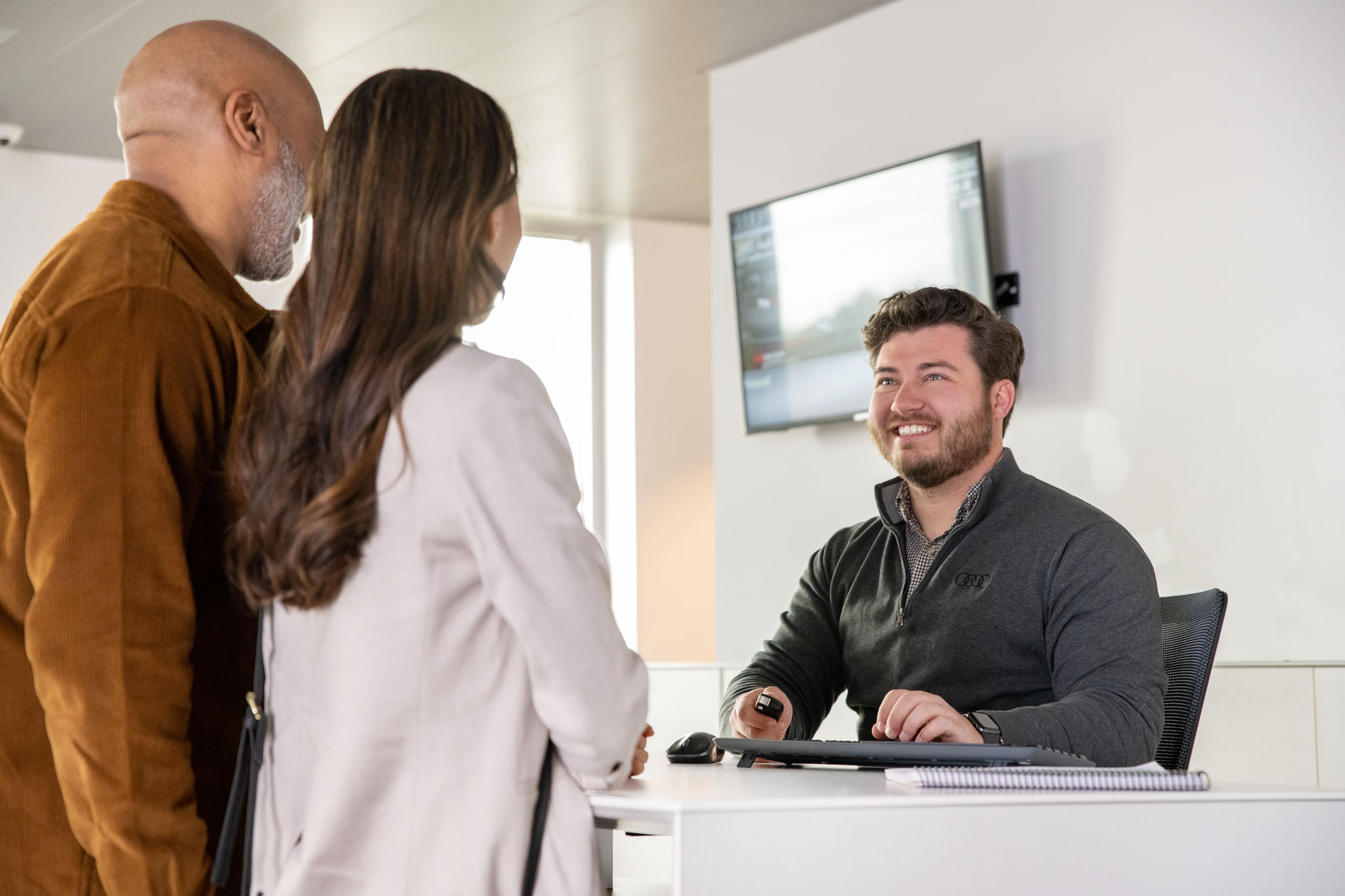 Customers talking with sales person at desk