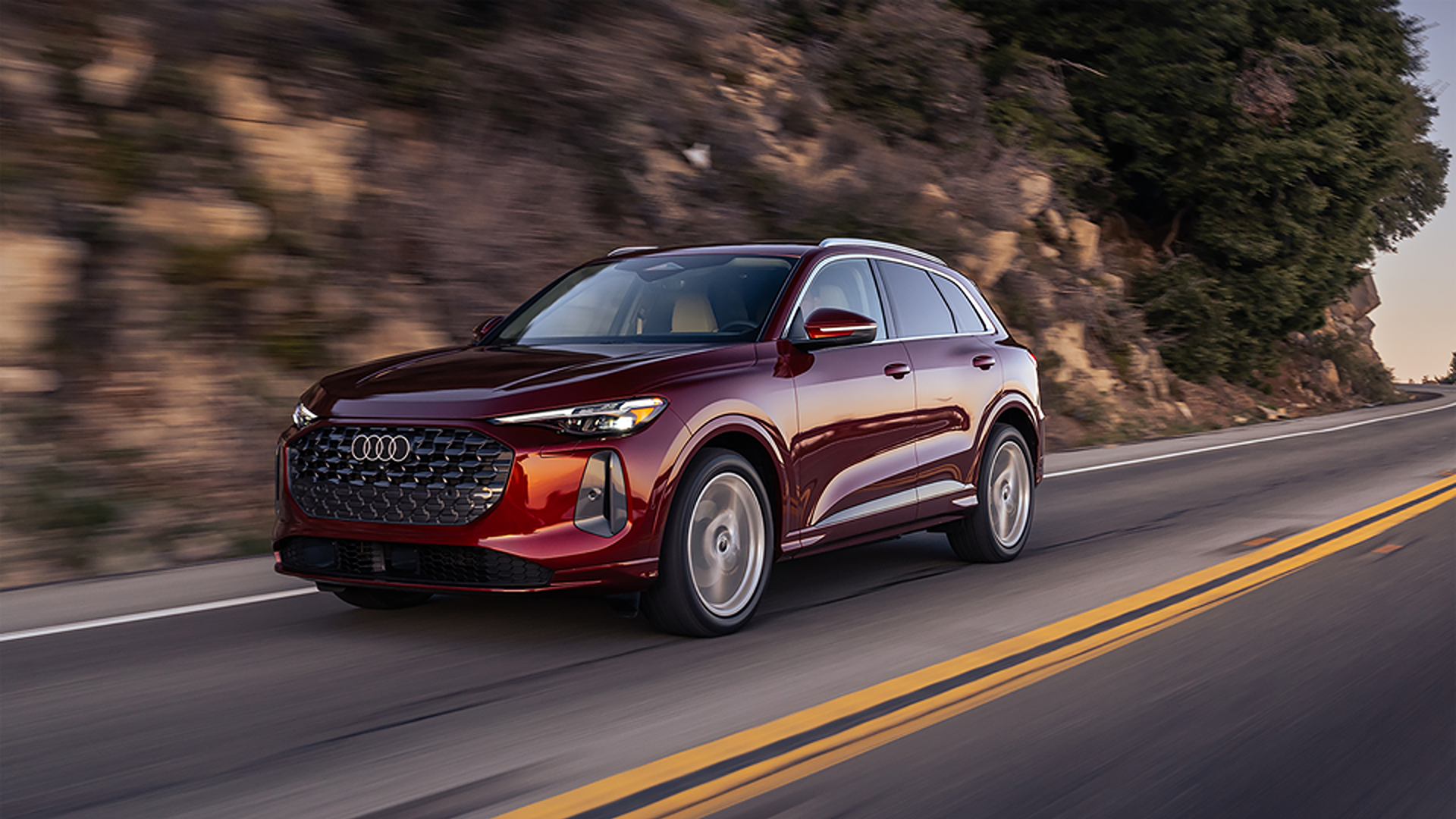 Red Q5 Premium Plus driving on a mountain road