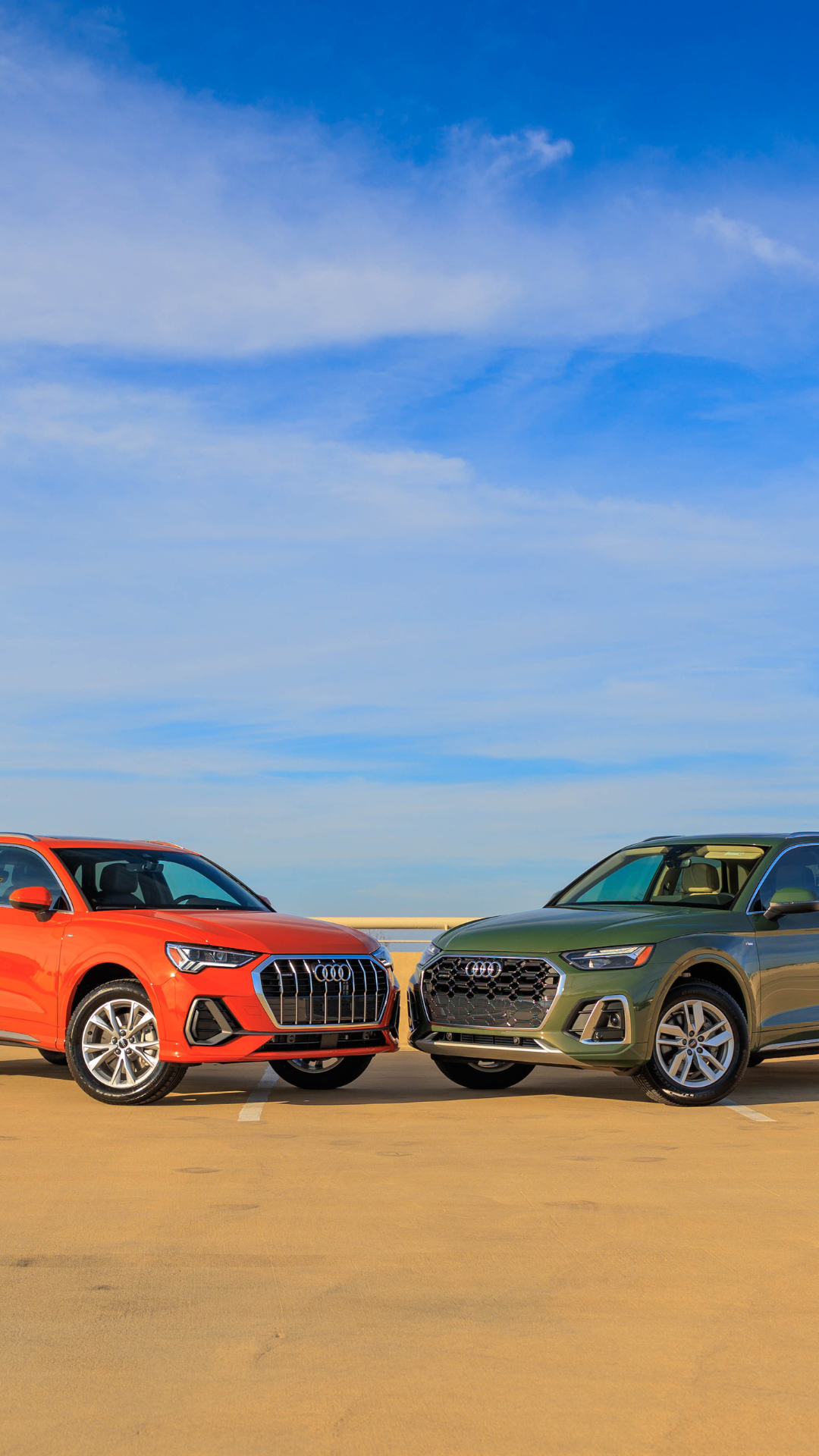 Audi Q3 parked next to an Audi Q5 with a blue sky in the background 