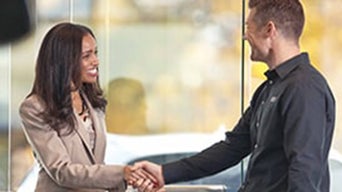Dealership employee shaking hands with a customer.