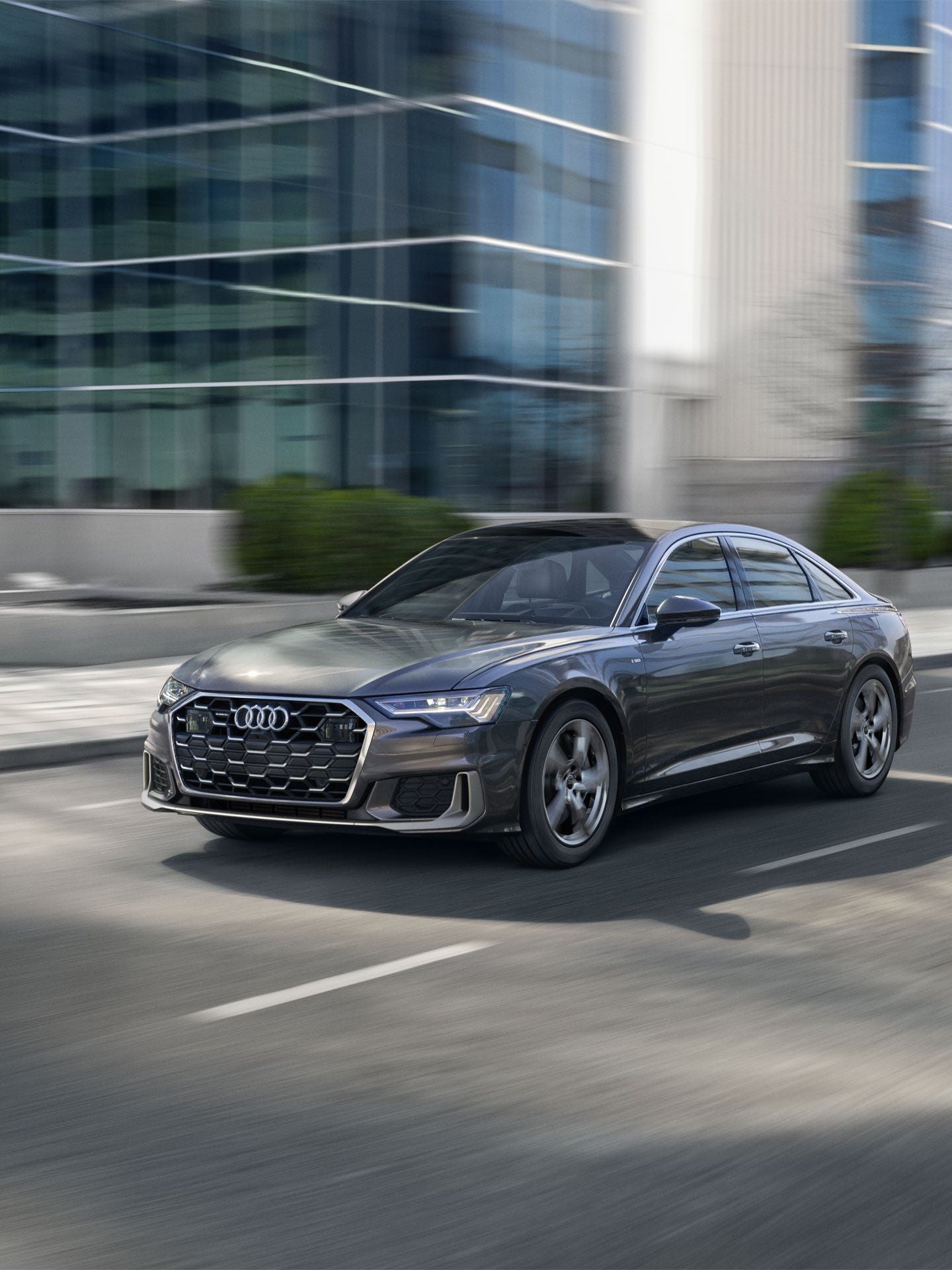 Three-quarter front-view of an Audi A6 in motion.