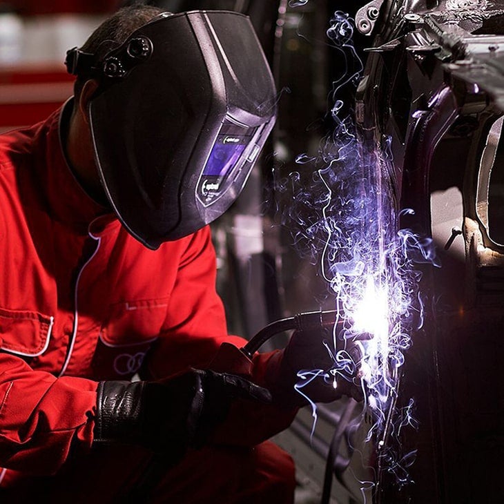 A mechanic working on an Audi vehicle. 