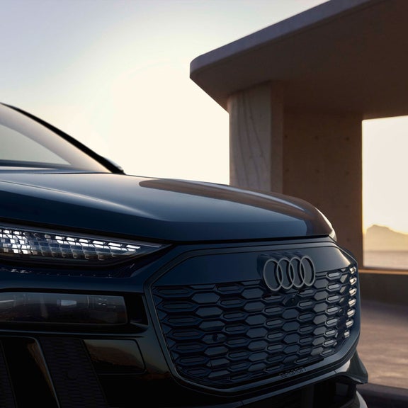 Close-up on the headlights of a Audi Q6 e-tron, showing the digital daytime running light signatures.
