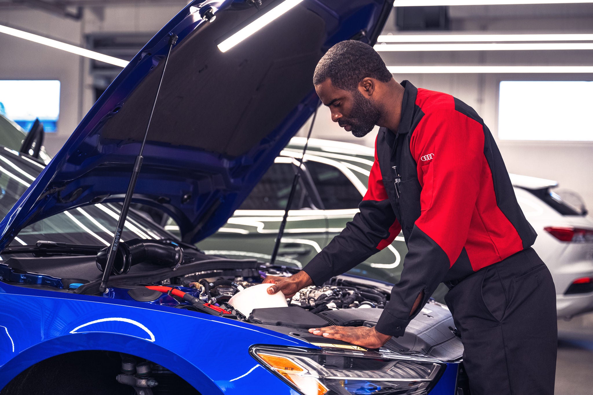 Audi service technician servicing a vehicle.