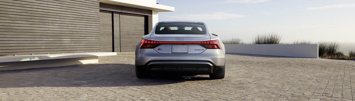 Rear view of Audi e‑tron GT EV with full‑width LED light bar.